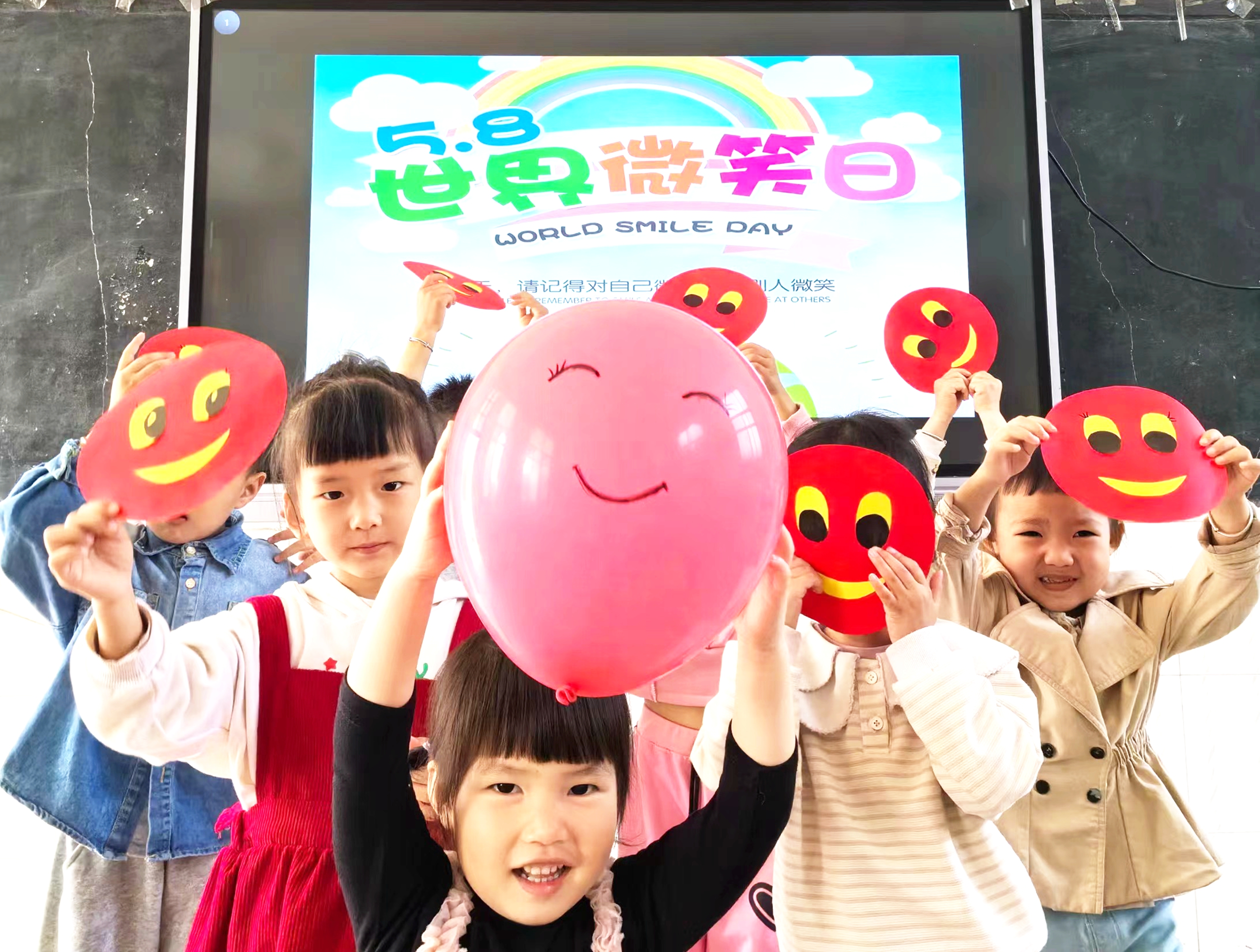 5月7日，湖南省永州市江永县夏层铺镇冷水铺中心幼儿园的孩子在“笑迎世界微笑日”活动上展示笑脸卡。 田如瑞 摄.jpg