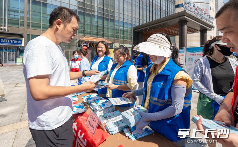 社区志愿者现场发放消防安全宣传资料。