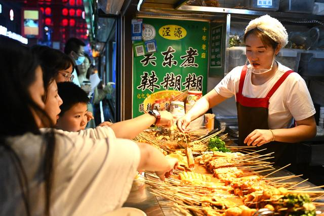 7月9日，游客在宁夏银川怀远夜市选购宁夏特色美食辣糊糊。新华社记者 毛竹摄