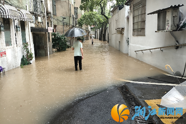 早上6点，社区书记李曙冒着雨，趟着没过小腿的雨水，在陈家湖小区开展暴雨安全隐患排查。_副本.png