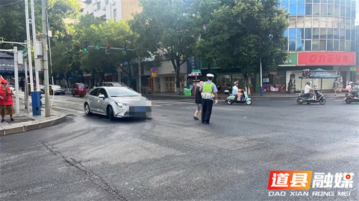 道县：老人拄拐杖过马路陷入车流 交警搀扶护送1_副本.png