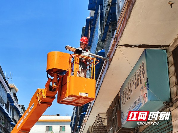 5.7月24日，邵阳市城市路灯管理所检修人员黄翀在北塔区宜兴街五巷进行寄墙灯具更换工作。(邓晨程13973992787).marked.jpg