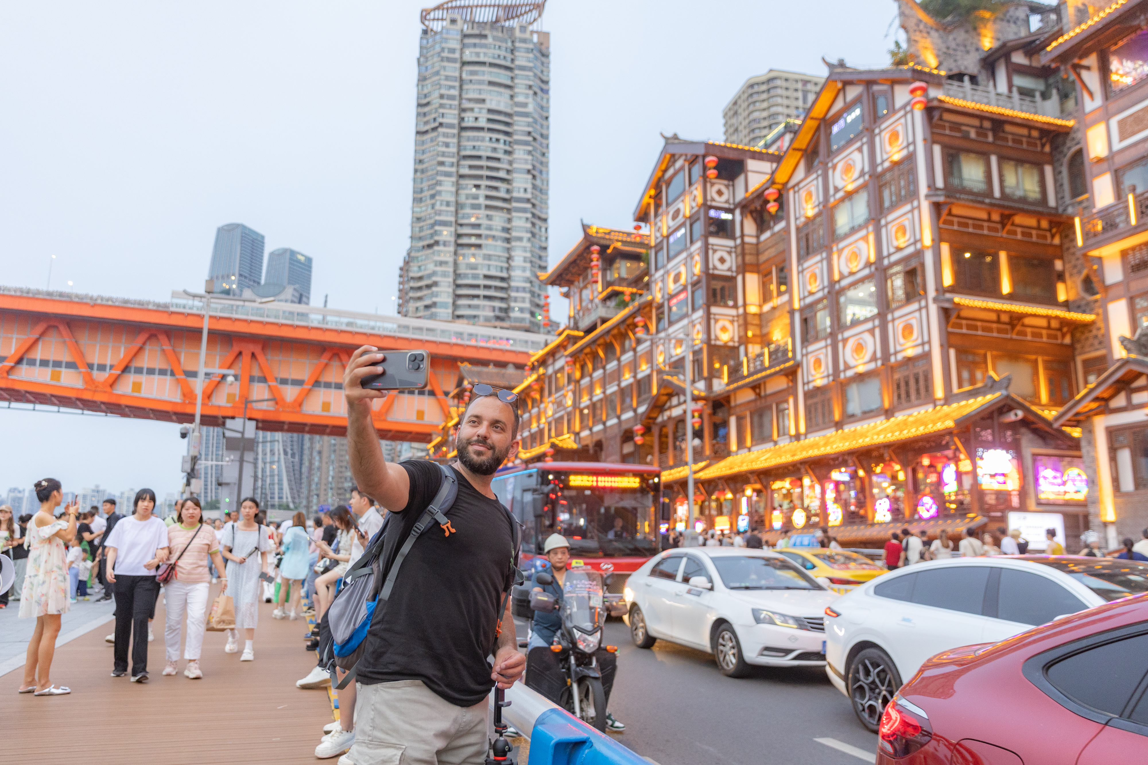 A tourist from Pakistan take a selfie at Hongyadong scenic area in Yuzhong district, in southwest China's Chongqing, July 8, 2024. (Xinhua/Huang Wei)