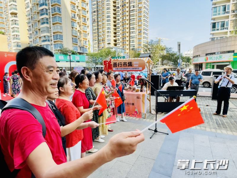 善行市集上，街頭音樂人伴奏，居民們高唱《我和我的祖國》。