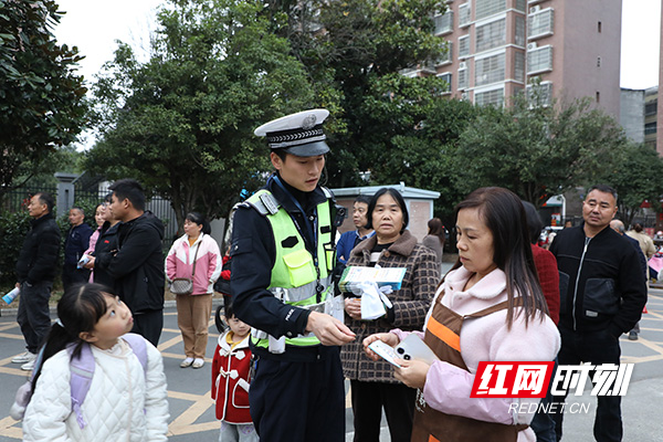 民警利用放学时间为学生家长宣讲交通安全常识.jpg