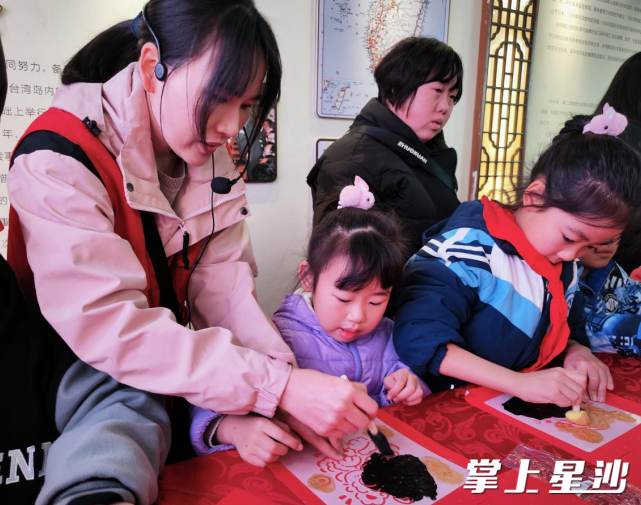 志愿者教孩子们制作拓印画。