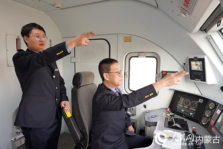 陈鹏与徒弟武斌正在驾驶万吨列车。王哲辉摄 陈鹏与徒弟武斌正在驾驶万吨列车。王哲辉摄