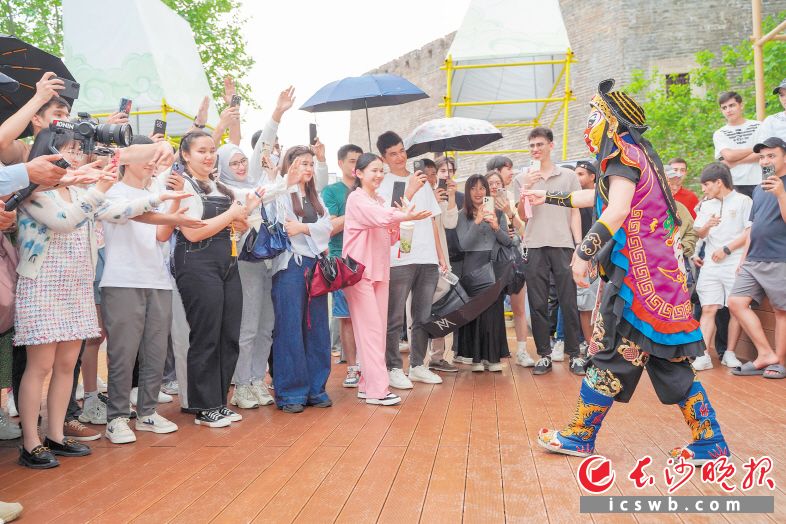 　　在阁下市集，留学生们欣赏精彩的变脸表演。