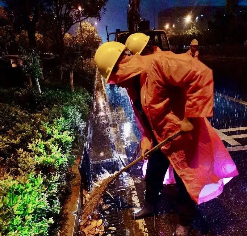 市政工人正准备打开雨水篦子促排。