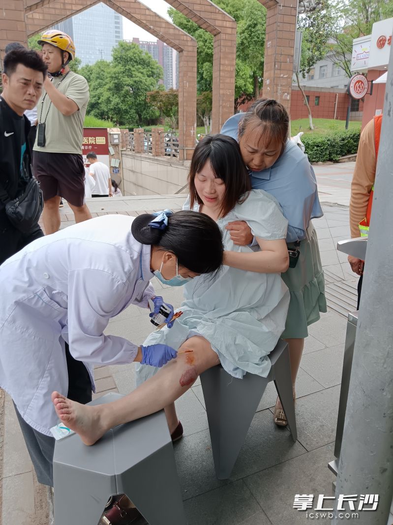 工作人员为符苗（中）初步处置腿部伤口。 均为受访者供图