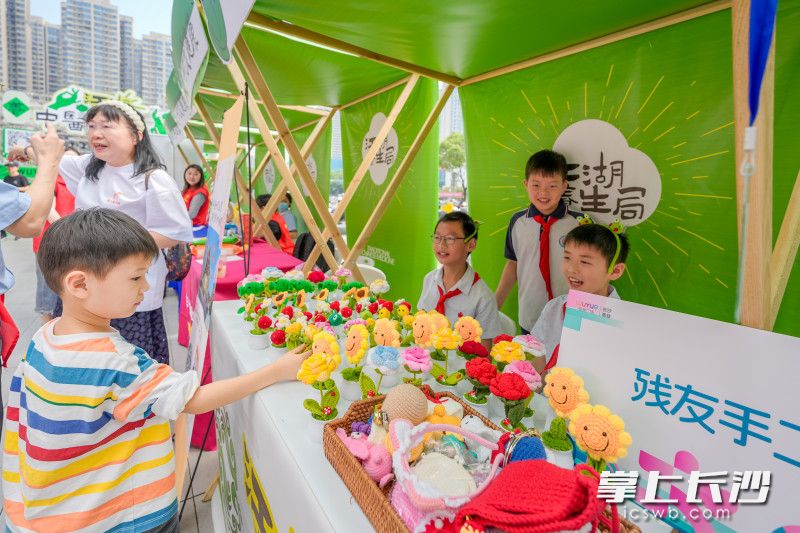 孩子们在推销残友手工作品。