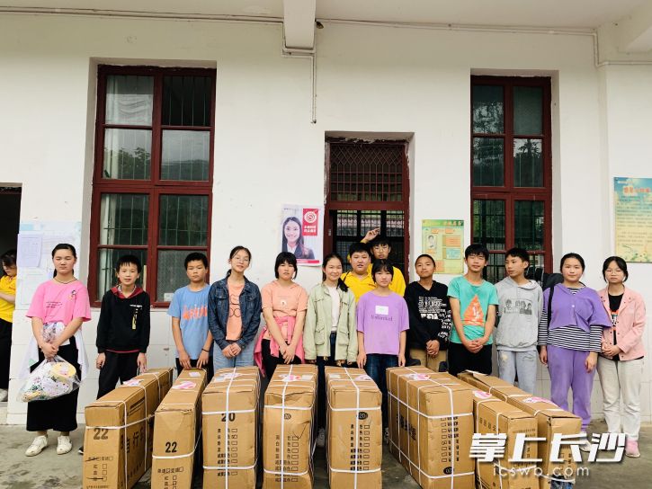 2021年六一兒童節(jié)，譚雋熙（第二排左一）在貧困山區(qū)陪伴留守兒童過節(jié)。均為受訪單位供圖