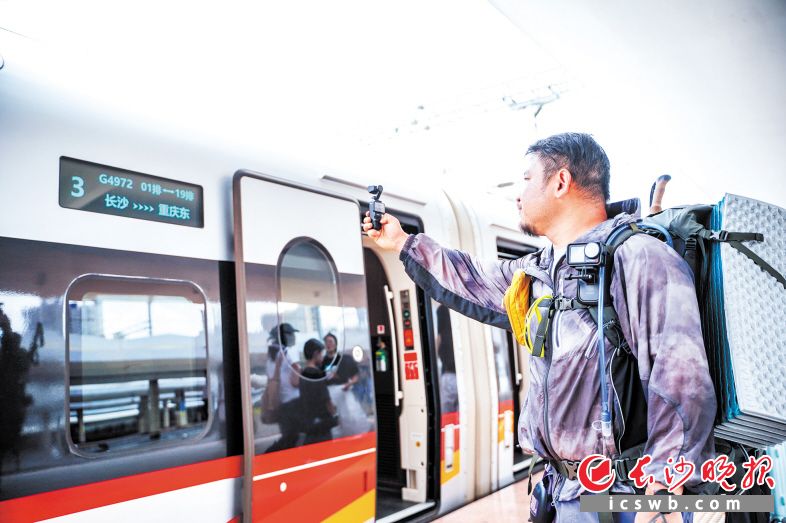 　　一位旅行博主拿出相机记录下首发列车瞬间。均为长沙晚报全媒体记者 易亿 摄
