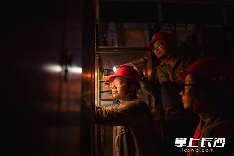 检修工人首先要做的就是为“心脏”体检，他们三人一组，有人打灯，有人测温，有人记录。