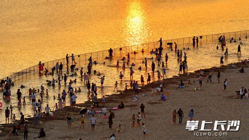 傍晚时分，夕阳把松雅湖的水面染成金色，众多市民游客在沙滩嬉戏，满满的都是人间烟火气。 均为长沙晚报全媒体记者 王志伟 通讯员 李沛慧 摄影报道