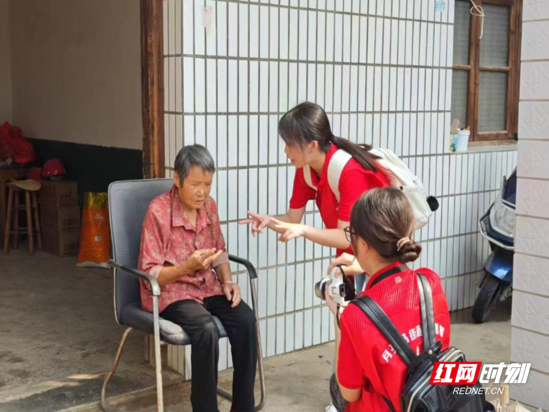 图为志愿队成员员为老人拍照。王康摄.png