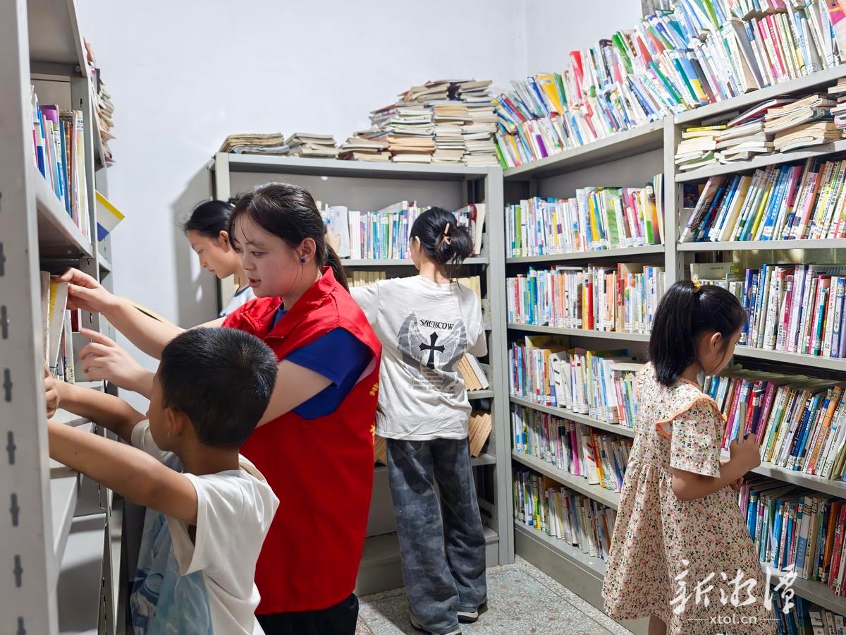 孩子们在志愿者引导下借阅书籍。（全媒体记者 尹义龙 摄）.jpg
