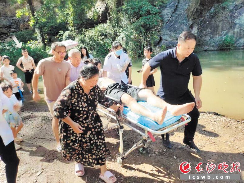 　　众人合力将溺水男子送往医院进一步救治，画面箭头标记处为蔺志广。　　长沙晚报通讯员 蔺辉 供图