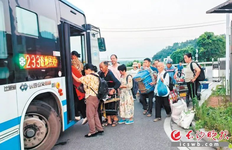 233路公交车首班车刚停稳，车门开启，一群拖着装满蔬菜的小拖车、提着沉甸甸菜篮的大叔大婶便有序地排队上车。均为长沙晚报全媒体记者 吴鑫矾 通讯员 张勇 胡健灵 摄影报道