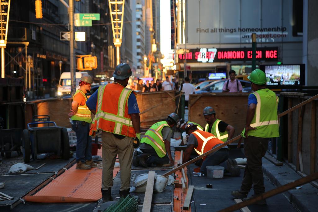 6月24日,建筑工人在美国纽约曼哈顿街头工作。新华社记者刘亚南摄