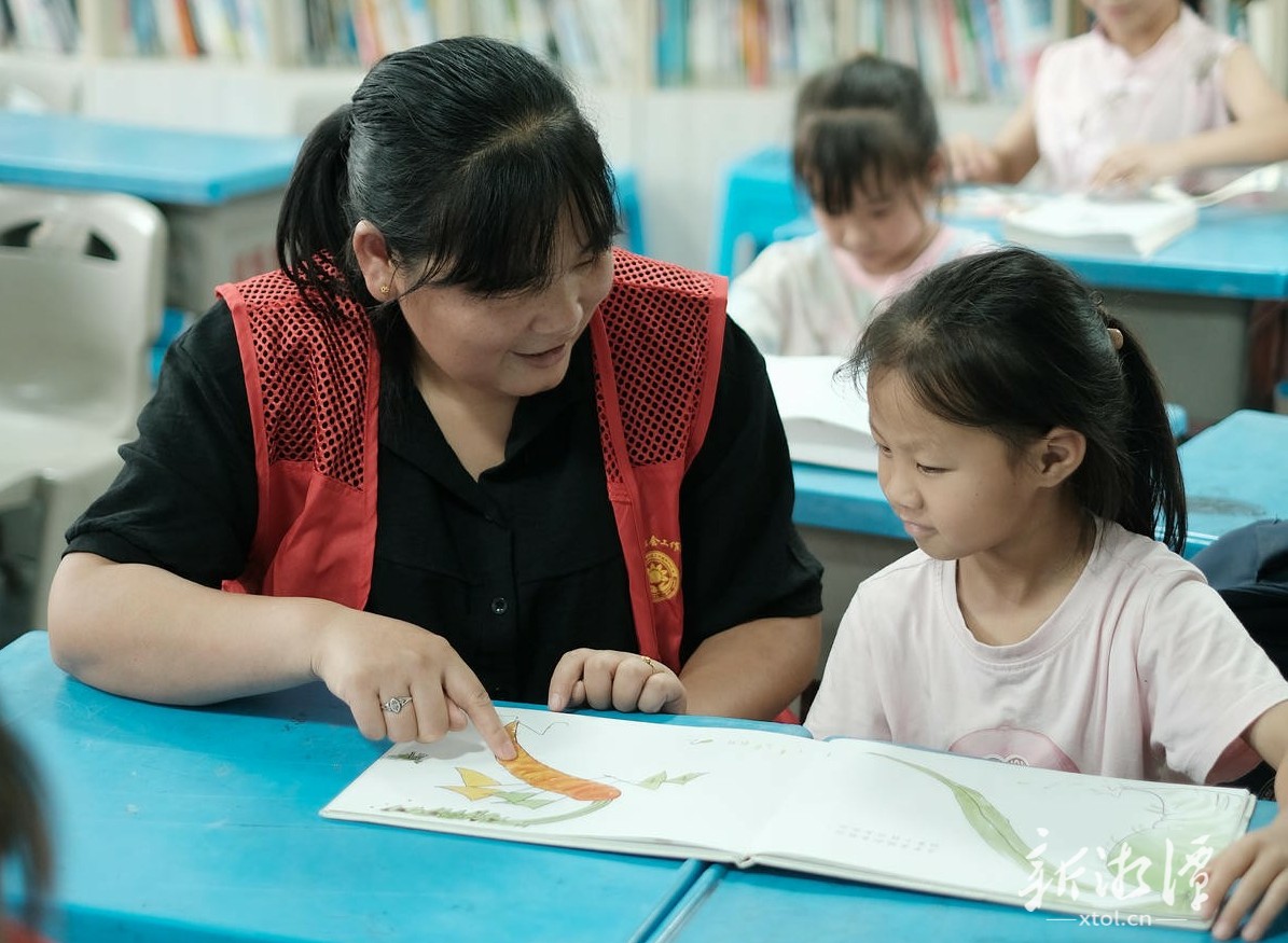 在紫竹村农家书屋,巾帼志愿服务队队员带着孩子们阅读绘本。(全媒体记者 邬雅琳 摄).jpg