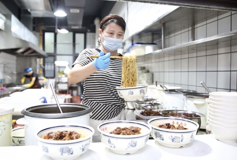 李红英在厨房拌面。受访单位供图