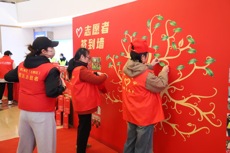 志愿者将写有自己美好祝愿的“树叶”粘贴在签到墙上。 志愿者将写有自己美好祝愿的“树叶”粘贴在签到墙上。