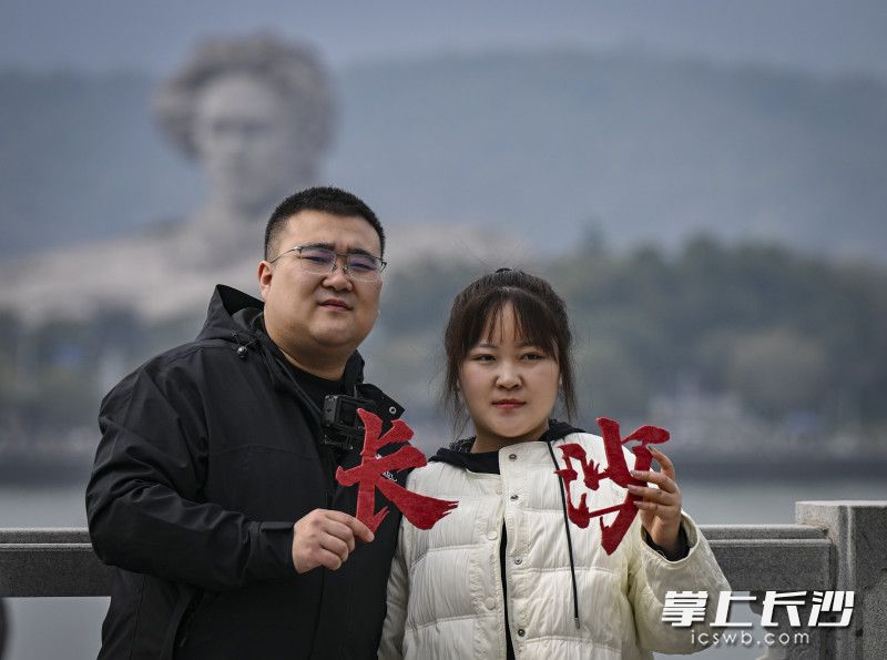 游客在恰同学少年广场拍照打卡。