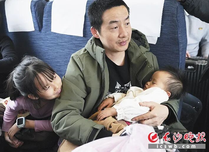 一位家长带着才2岁的小孩乘坐绿皮火车。本版摄影 长沙晚报全媒体记者 邹麟 一位家长带着才2岁的小孩乘坐绿皮火车。本版摄影 长沙晚报全媒体记者 邹麟