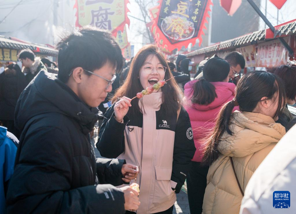 在北京沙河大集,一名女孩在品尝特色小吃。新华社记者 才扬摄