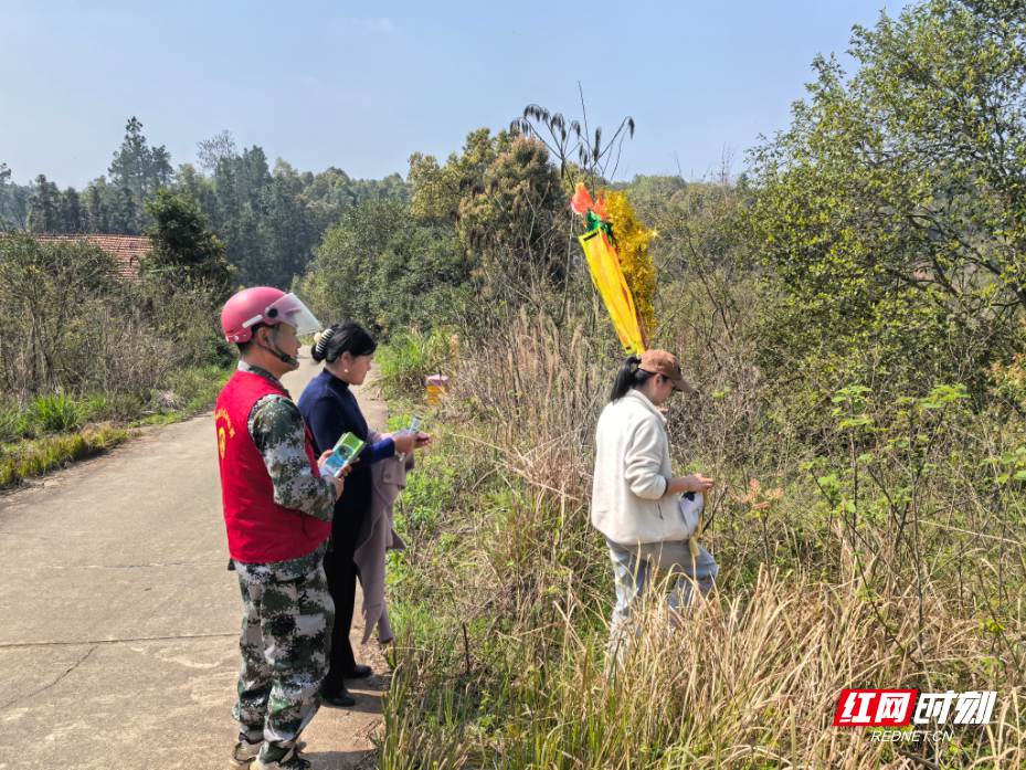 图为童强在重点地段劝导上山祭祀的群众.jpg