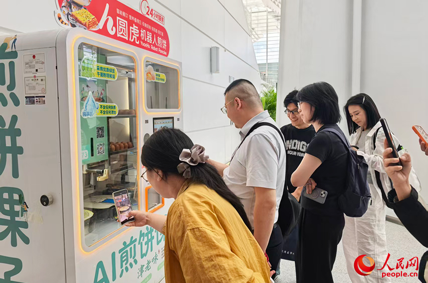 2026世界智能产业博览会上,煎饼馃子机器人前,排起了长队。人民网记者 陶建摄