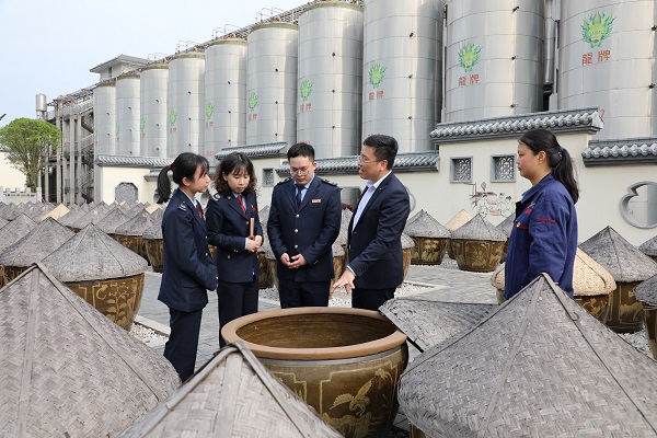 4月12日，国家税务总局湘潭经济技术开发区税务局在龙牌食品股份有限公司开展“送政策解难题优服务”助企纾困行动，图为税务工作人员与龙牌酱油工作人员一同在晾晒场，查看酿制酱油、了解企业生产经营情况，为老字号企业纾困解难。3.JPG