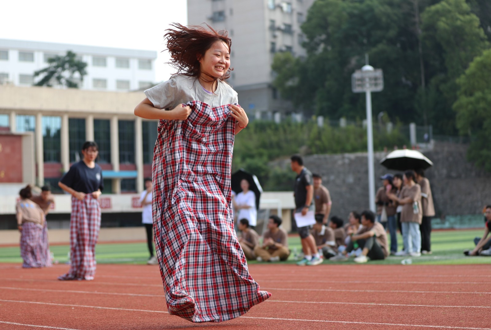 6月6日，在湖南省衡阳市，南华大学2023届毕业生在学校球场进行袋鼠跳比赛。 (1).JPG