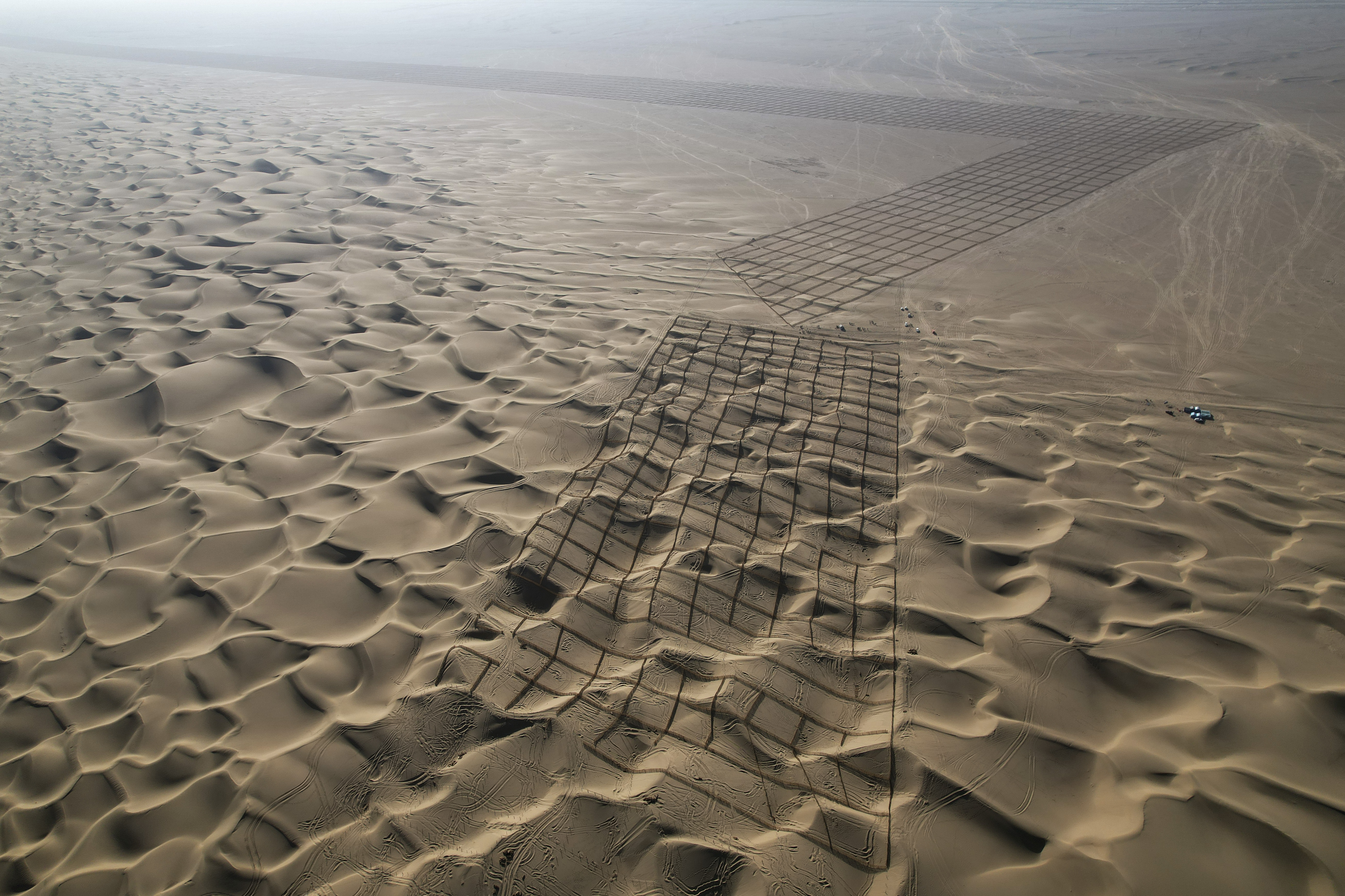 An aerial drone photo shows upright sand barriers set up on the desert in Pishan County in Hotan, northwest China's Xinjiang Uygur Autonomous Region, Nov. 27, 2024. (Photo by Zou Yi/Xinhua)